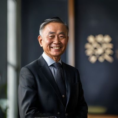 朝桐光创始人陈光明先生，身着深色正装，面带自信笑容，站在公司会议室内，背景为品牌标志墙，展现领导者气质